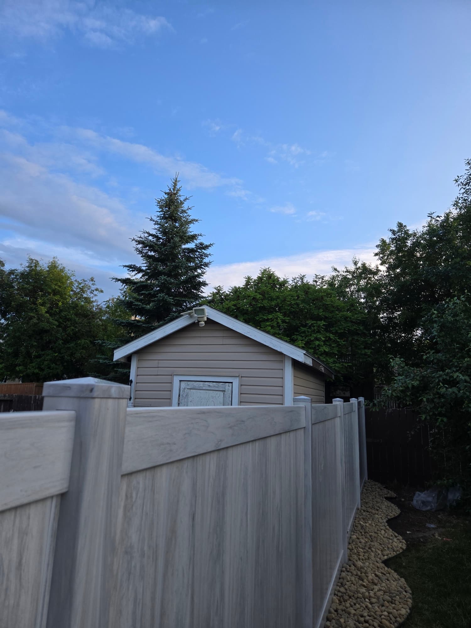 Composite deck + river rock surround — Rosewood, Saskatoon